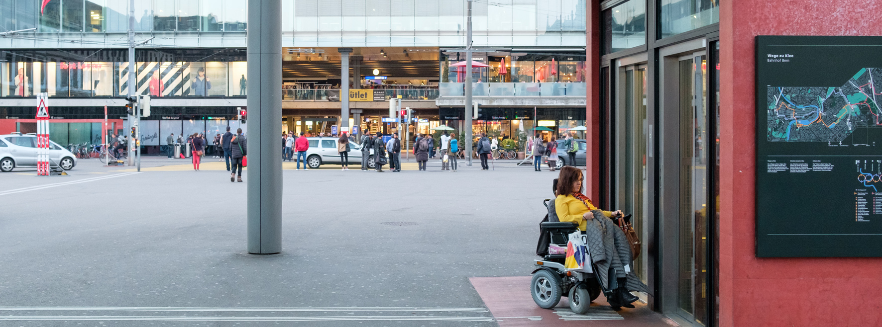 wartende Rollstuhlfahrerin vor Lift auf dem Bahnhofplatz Bern