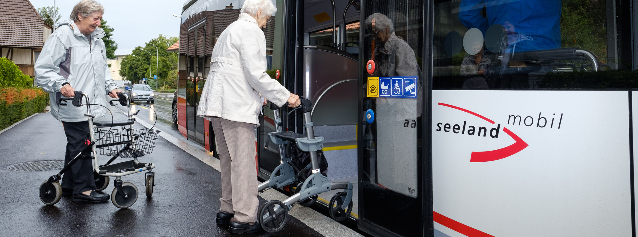 Person mit Rollstuhl beim Einstieg in den Bus an Haltestelle mit hoher Haltekante